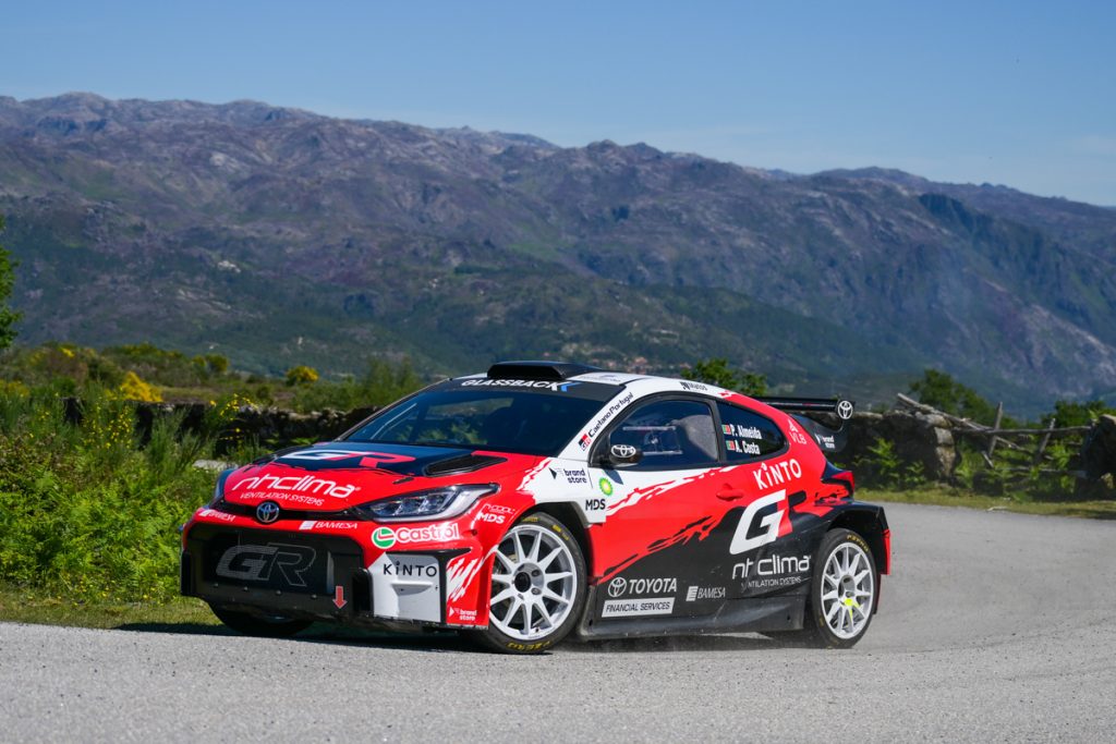 Veículo de corrida Toyota Gazoo Racing em movimento numa estrada rural