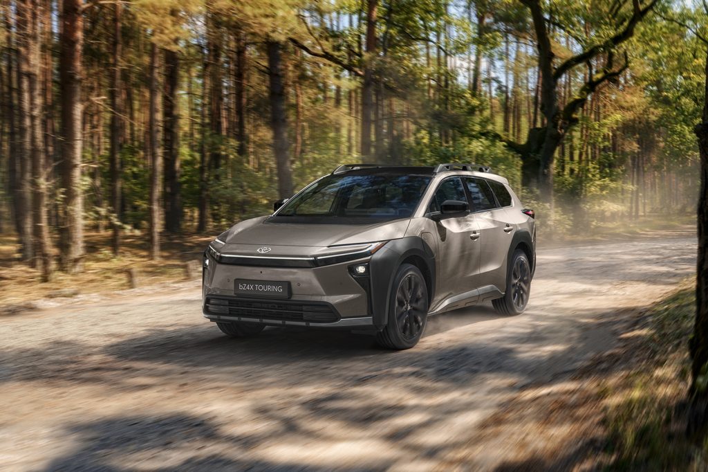 Veículo Toyota bz4X Touring e movimento numa estrada rural com árvores à volta