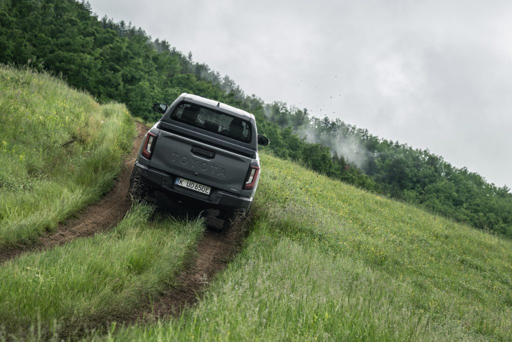 hilux da toyota a andar no meio de um campo de erva natural