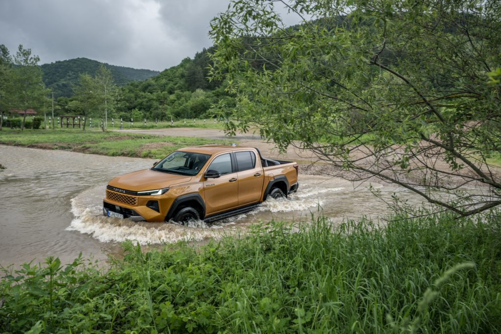 toyota hilux atravessa curso de água em ambiente todo-o-terreno