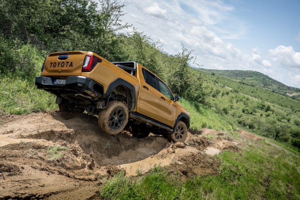 Veículo da toyota Hilux num obstáculo lamacento em ambiente rural