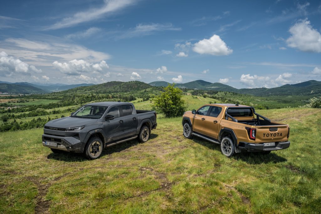 dois veículos hilux da toyota parados em ambiente rural