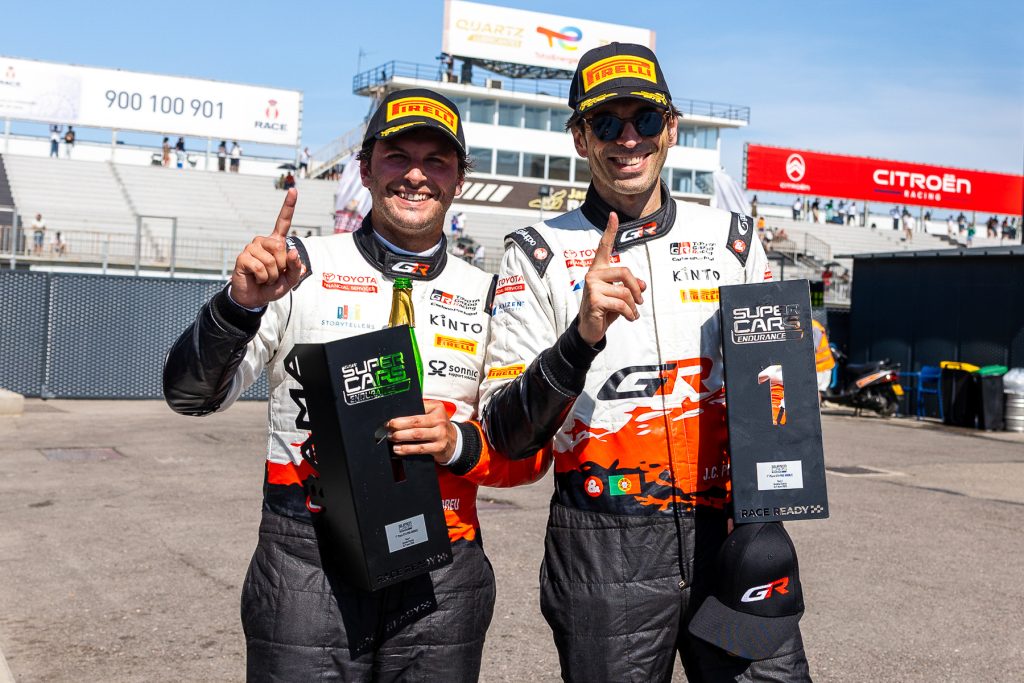 Dois pilotos de corrida da Toyota felizes a segurar o prémio