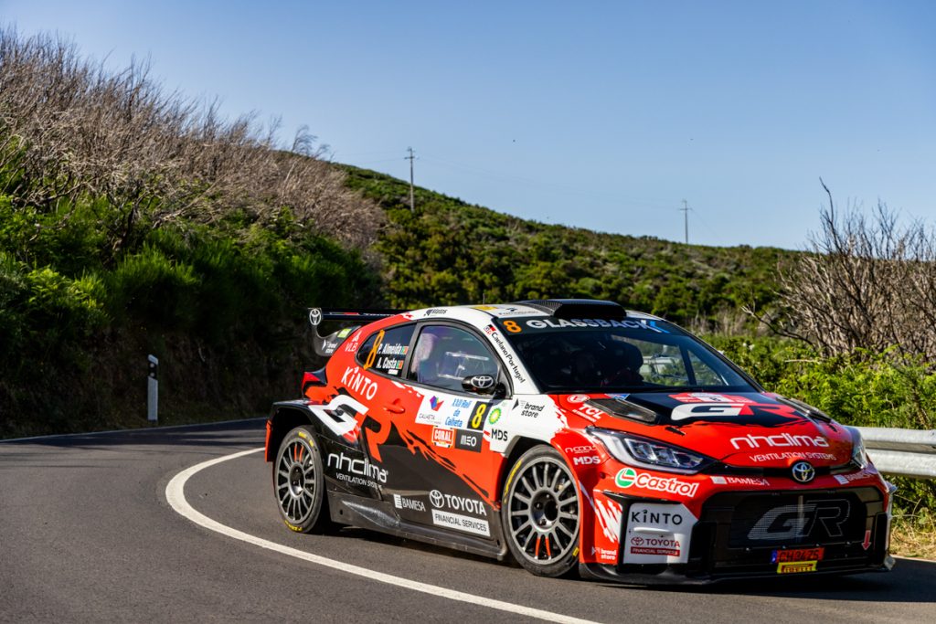 veículo de corrida da Toyota em andamento numa estrada em ambiente de natureza