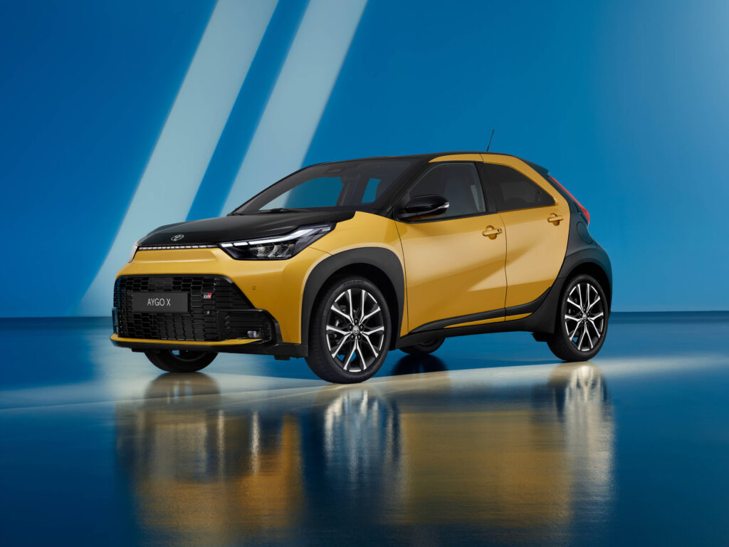 Vista de 3/4 frontal do novo Aygo X Hybrid, na cor Mustard