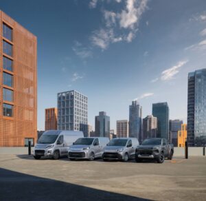 Gama Proace e modelo pick-up Hillux elétricos fotografados numa perspectiva 3/4 num terraço com edifícios urbanos no fundo