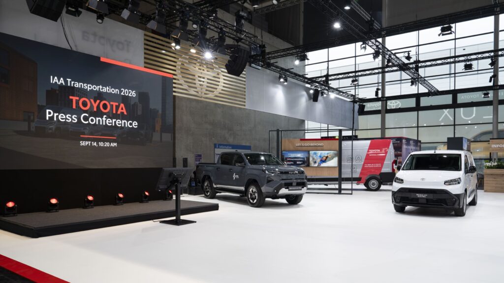 Fotografia em detalhe do stand da Toyota no IAA Transportation 2026. Dois veículos Toyota encontram-se em destaque na imagem